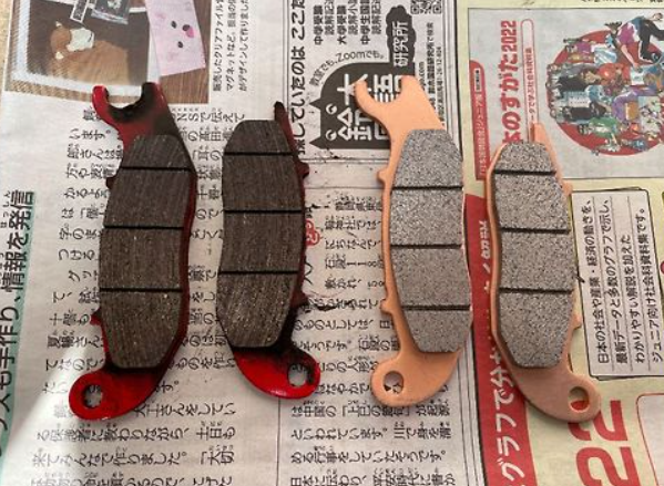 Two sets of brake pads on a newspaper background