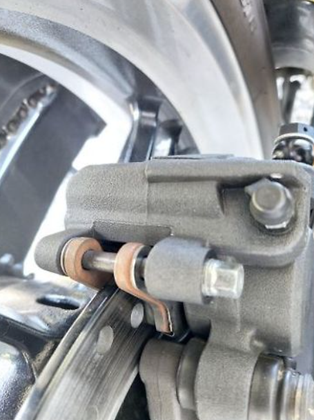Close-up of a motorcycle brake system with metallic components.