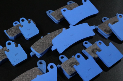 Set of brake pads with blue ceramic material on a dark background