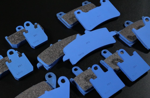 Set of brake pads with blue ceramic material on a dark background