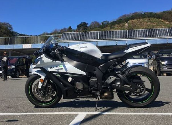 Motorcycle on a road with solar panels in the background