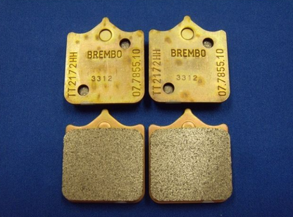 Two pairs of Brembo brake pads on a blue background