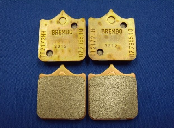 Two pairs of Brembo brake pads on a blue background