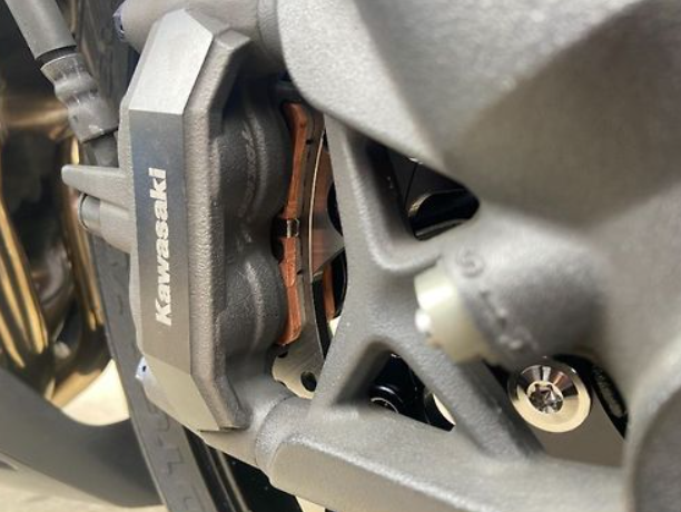 Close-up of a Kawasaki brake pad on a motorcycle.