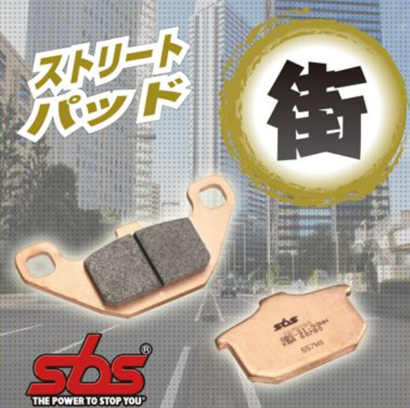 Brake pads with SBS logo and Japanese text on a blurred cityscape background