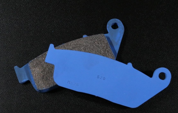 Pair of brake pads with blue outer casing on a black background