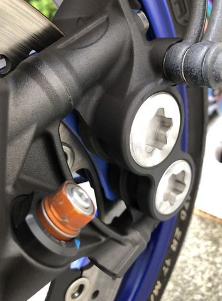 Close-up of a motorcycle's foot peg and chain area