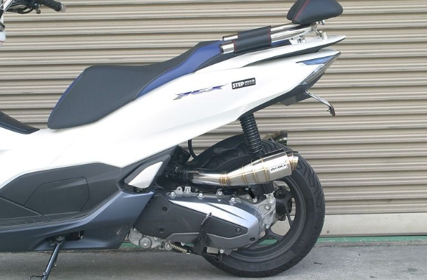 White scooter with black seat against a metallic shutter background