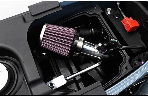 Close-up of a motorcycle air filter with a purple filter element and metal housing.