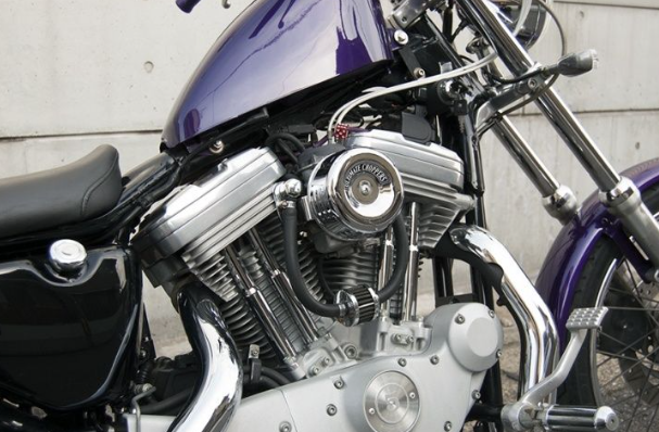 Close-up of a motorcycle engine with visible branding on a gray background
