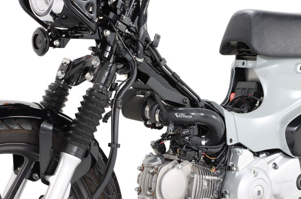 Close-up of a motorcycle's engine and suspension system on a white background