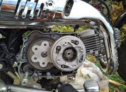Close-up of a motorcycle engine with visible gears and chrome parts.