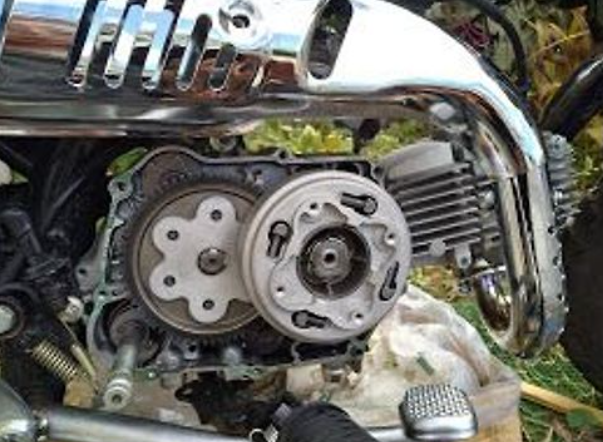 Close-up of a motorcycle engine with visible gears and chrome parts.