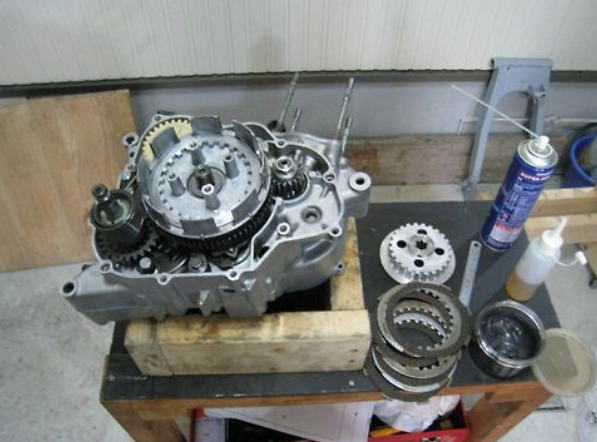 Mechanical engine components on a workbench with tools in the background