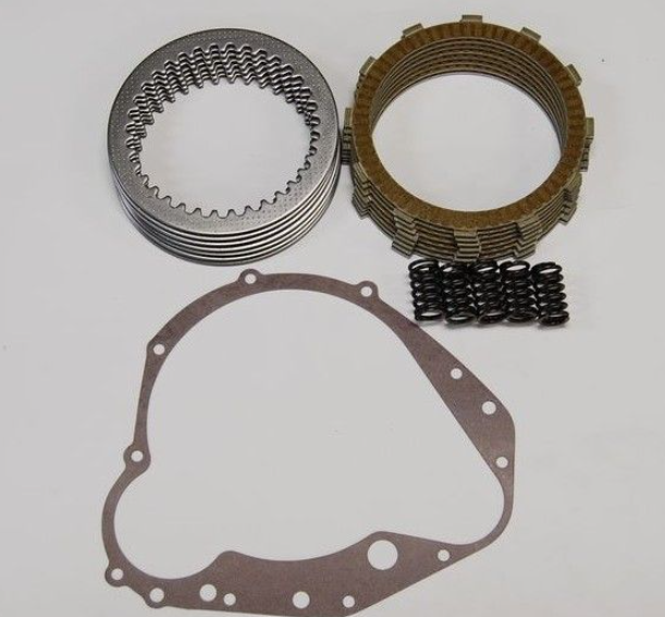 Mechanical parts including a gasket, springs, and clutch plates on a white background
