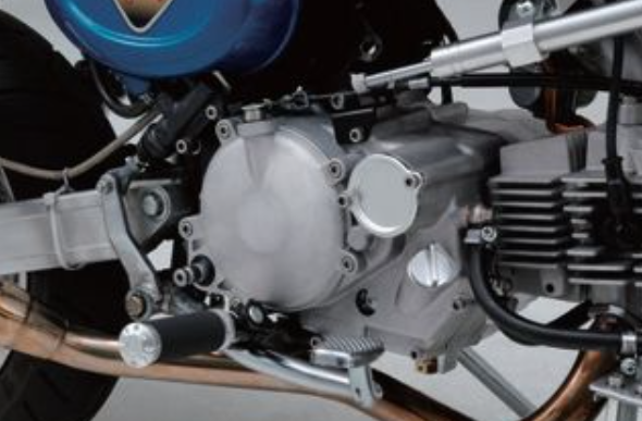 Close-up of a motorcycle engine and exhaust system on a white background