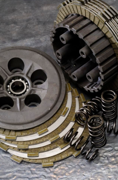 Mechanical components including a clutch plate, springs, and gears on a metallic surface.