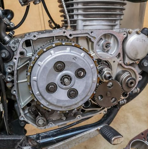 Close-up of a motorcycle engine with gears and mechanical components.