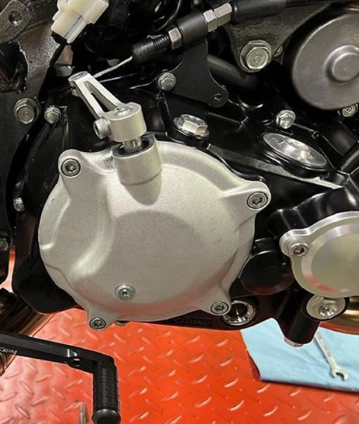 Close-up of a motorcycle engine with metallic components on a red surface