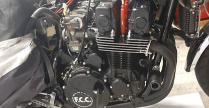 Close-up of a motorcycle engine with 'FCC' branding.