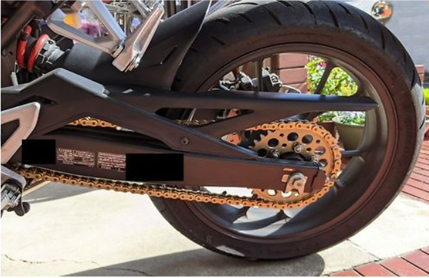 Close-up of a motorcycle wheel with chain and sprocket