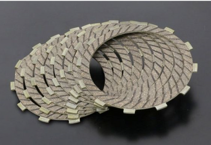 Two circular brake pads on a dark background