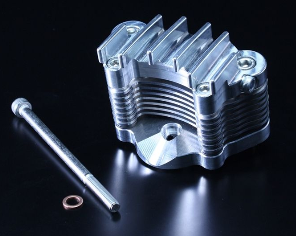 Metallic engine component with a bolt and washer on a black background