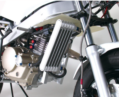 Close-up of a motorcycle engine and cooling system on a white background