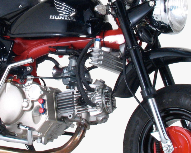 Close-up of a Honda motorcycle engine and front wheel on a white background