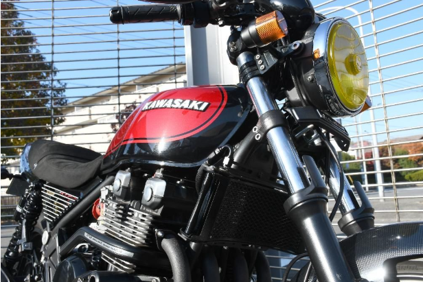 Kawasaki motorcycle with a red gas tank in front of a building