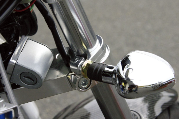 Close-up of a motorcycle mirror and lock mechanism.