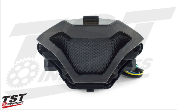 Black motorcycle seat with mesh design on a white background, featuring TST Industries logo.