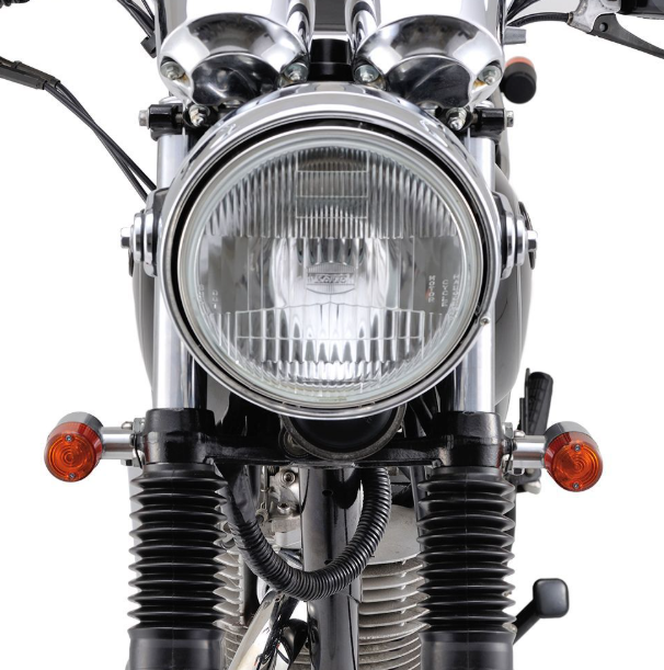 Close-up of a motorcycle headlight with clear lens and metal frame.