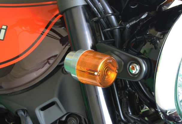 Close-up of a motorcycle's orange turn signal light.