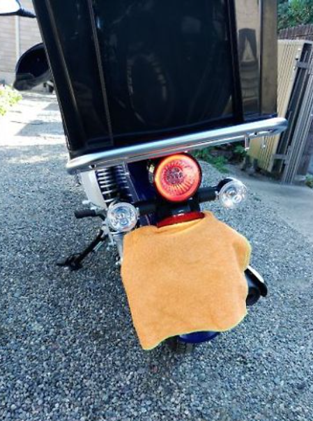 Close-up of a motorcycle with a towel on the handlebar against a blurred background