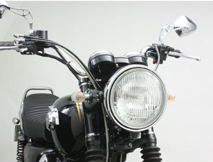 Close-up of a motorcycle's headlight and handlebars on a light gray background