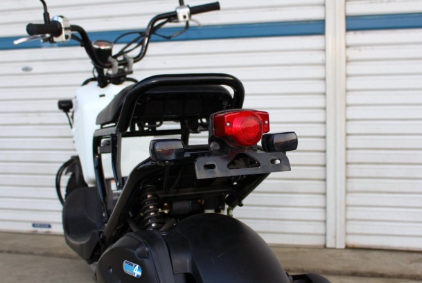 Motorcycle with a red tail light against a white wall