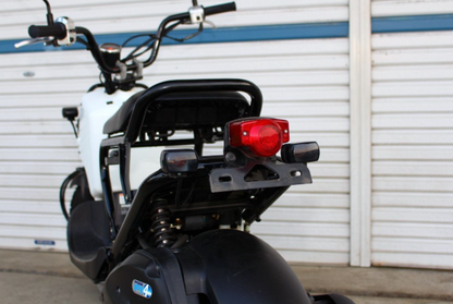 Motorcycle with a red tail light against a white wall