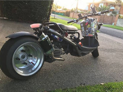 Three-wheeled motorcycle on a driveway with a residential background