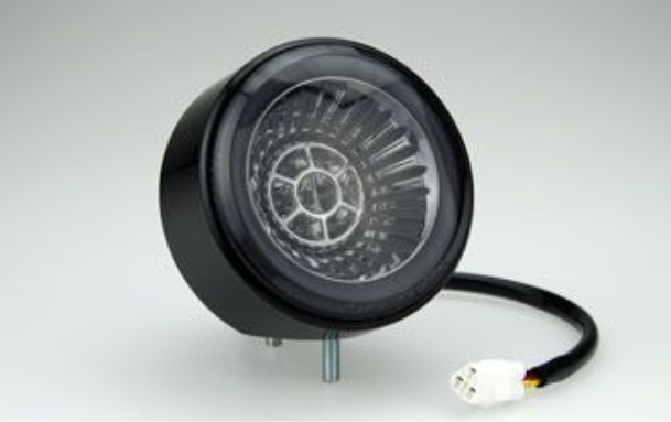 Black circular device with a cable on a white background
