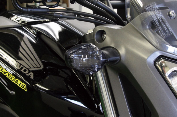 Close-up of a motorcycle with a visible Honda logo and 'Takegawa' label.