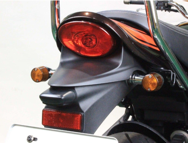 Close-up of a motorcycle's rear lights and exhaust on a white background