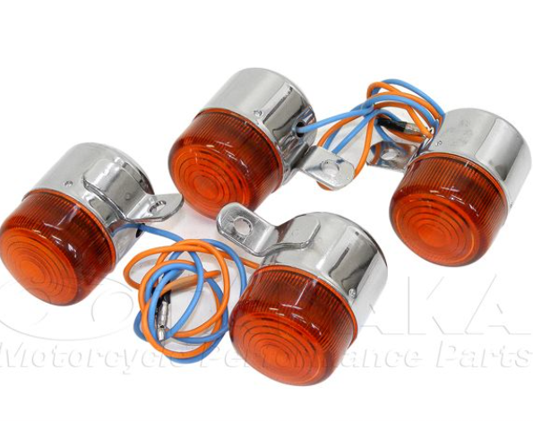 Four orange motorcycle turn signals with wiring on a white background