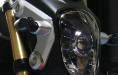 Close-up of a motorcycle headlight and gold suspension fork