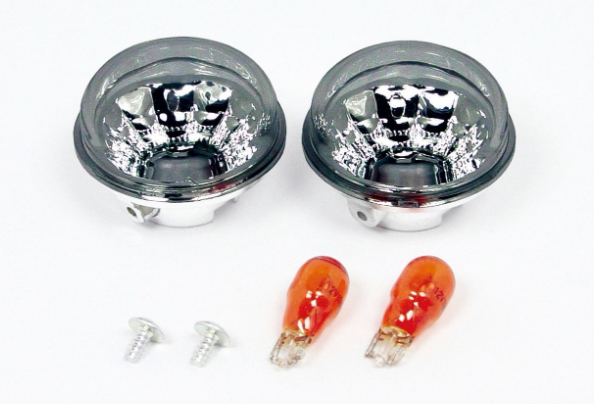 Two car fog lights with clear lenses and silver bases, accompanied by two orange bulbs on a white background.