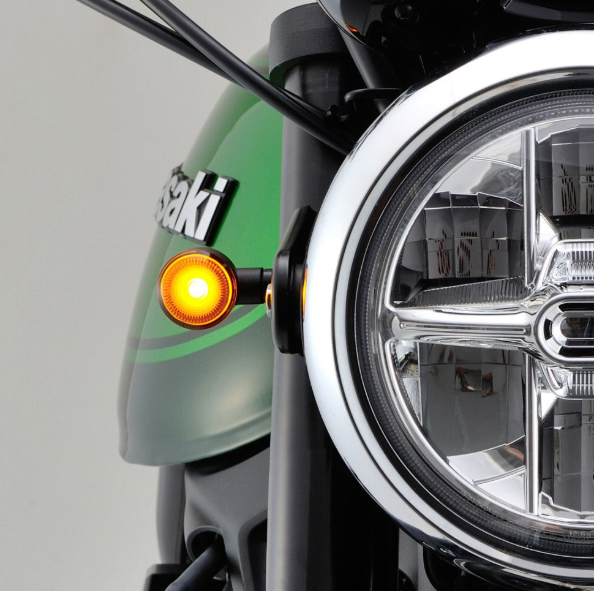 Close-up of a motorcycle headlight with 'Suzuki' branding on a gray background