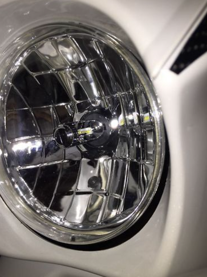 Close-up of a car headlight with a shiny metallic finish.