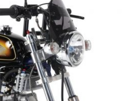Close-up of a motorcycle's headlight and handlebar on a white background