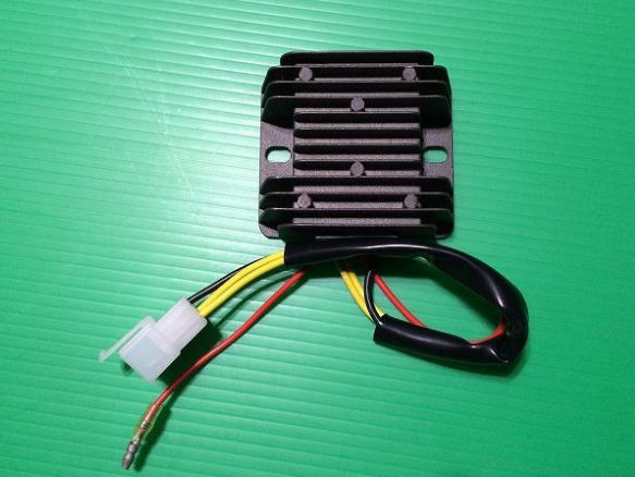 Rectangular metal component with wires on a green textured background