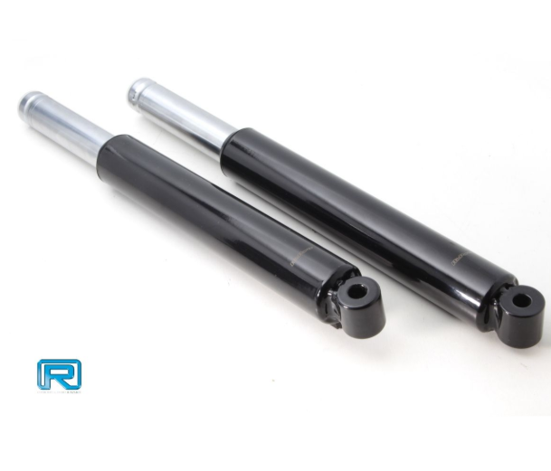 Two black shock absorbers with silver tops on a white background